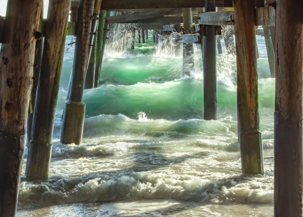 Soft green waves crahing through the wood pilings of the San Clemente pier on a warm summer afternoon creating a tremendous roar, yet it is so peaceful and calming.