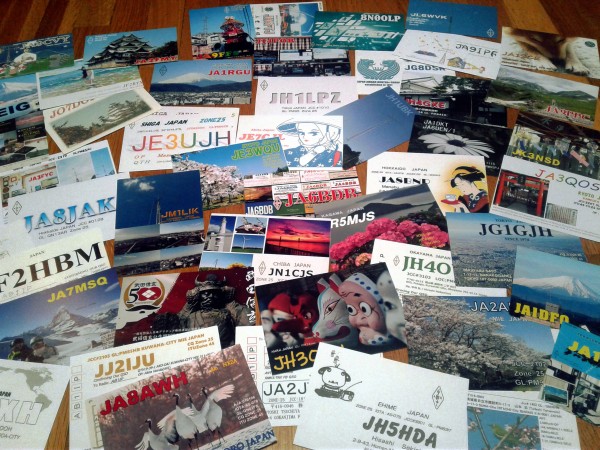 Several dozen slightly older postcards from amateur radio stations on the floor.  Most  are from Japan, most show a colour photo of operators' locations or interests, and almost all prominently show a station call sign.