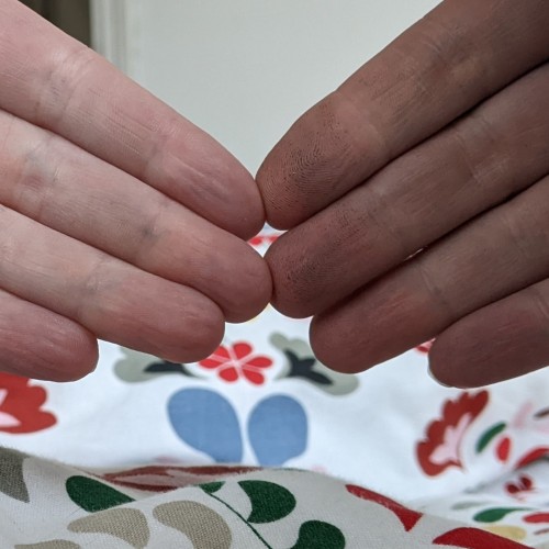 Quatre doigts de chaque main en symétrie.
La main droite présente des traces de saleté sur le bout des doigts