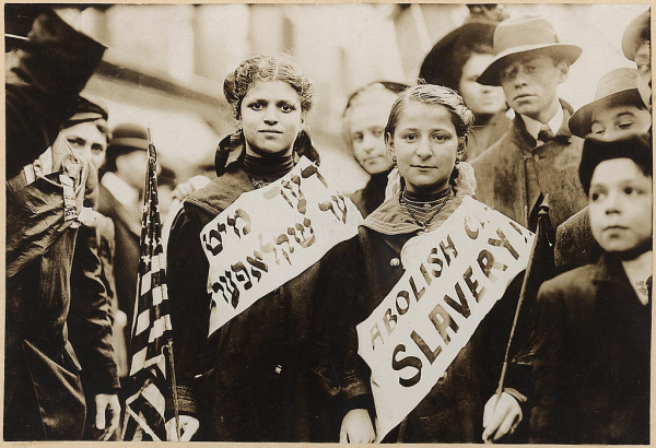 Title: [Protest against child labor in a labor parade]
Date Created/Published: [1909 May 1]
Medium: 1 photographic print.
Summary: Photograph shows half-length portrait of two girls wearing banners with slogan "ABOLISH CH[ILD] SLAVERY!!" in English and Yiddish, one carrying American flag; spectators stand nearby. Probably taken during May 1, 1909 labor parade in New York City.
Reproduction Number: LC-DIG-ppmsca-06591 (digital file from original photo, later scan) LC-DIG-ppmsc-00150 (digital file from original photo, earlier scan) LC-USZ62-22198 (b&w film copy neg.)
Rights Advisory: No known restrictions on publication.
Call Number: LOT 10876-2 [item] [P&P]
Repository: Library of Congress Prints and Photographs Division Washington, D.C. 20540 USA

Notes:
    Bain News Service photograph.
    Forms part of: George Grantham Bain Collection (Library of Congress).

    Published in: American women : a Library of Congress guide for the study of women's history and culture in the United States / edited by Sheridan Harvey ... [et al.]. Washington : Library of Congress, 2001, p. 347.
 
   Original negative may be available: LC-B2-696-9

