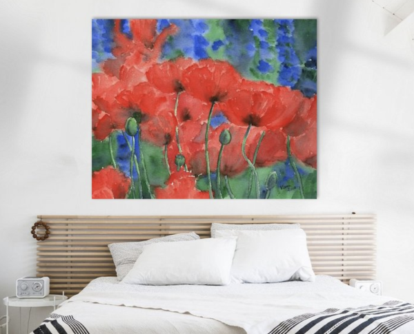 Red poppies with blue delphinium flowers is a hand-painted watercolour painting in landscape format by the artist Karen Kaspar.
Bright red poppies and deep blue delphiniums bloom together in a flower bed in a summer garden. The red poppies are the focal point of the painting. Their luminosity is further emphasised by the contrasting background of cool blue and green tones. The picture is painted in a loose, flowing style, which gives the flowers a sense of movement, as if they are swaying in the summer wind.
The painting hangs above a bed in a bedroom.