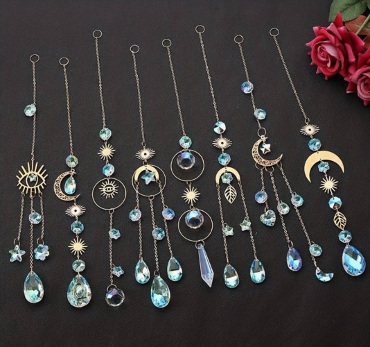 photo of lots of sun catchers in silver and light blue with lots of moon, sun, leaf and eye shaped pendants and glass pendants and connectors 