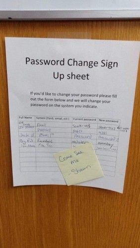 A sign-up sheet titled "Password Change Sign Up sheet" pinned on a wooden surface, with a sticky note that reads "Come See Me - Shawn". The sheet includes columns for full name, system (for example, email), current password, and new password.