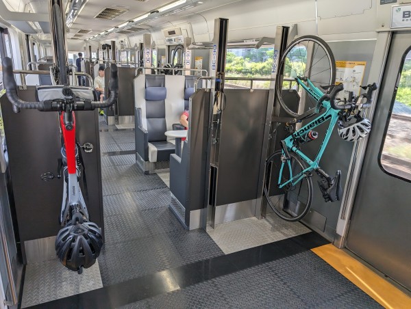 Two road bicycles hanging on racks on a modern train in Japan