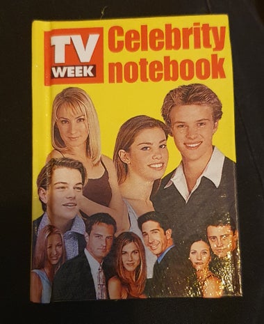 Photo of a miniature notebook that came with an edition of Australia's TV week magazine in the late 90s. The title is "TV week celebrity notebook" and features headshot photos of popular Australian and US actors on a bright yellow background, including Leonardo Dicaprio, the cast of friends, Lisa mccune, and people from Neighbours