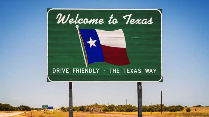 Road sign with a Texas state flag that says "Welcome to Texas. Drive friendly, the Texas way."