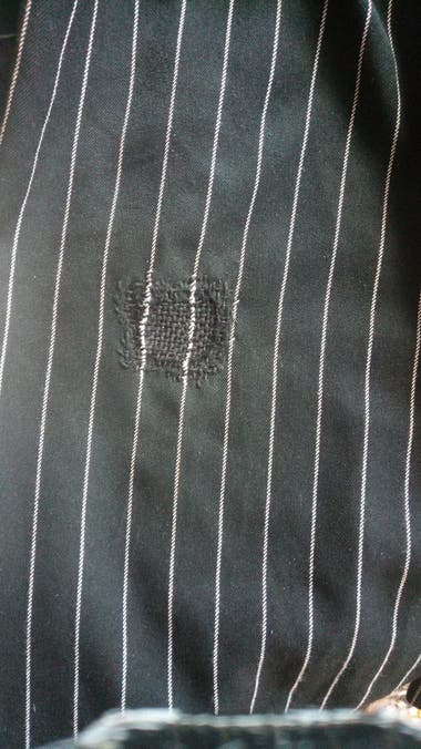 Slightly visible mended hole in pinstriped pants