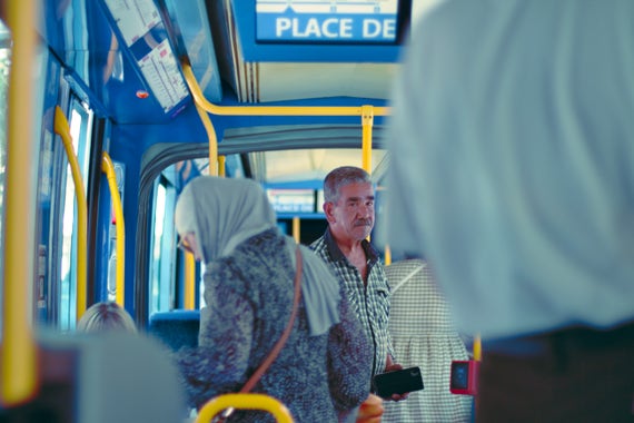 a man in a crowded tramway, looking at the camera