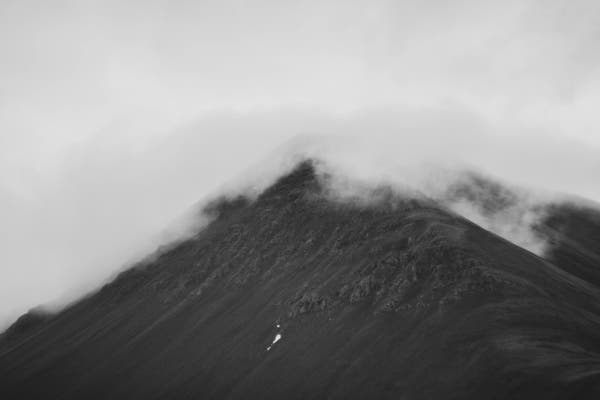 Black and white photos. 
Top of the mountain covered in thick fog and disappears into the grey sky