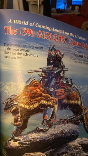A cyber mountain lion creature roaring atop a rocky outcrop with a robot guy wielding a laser rifle on his back. Photo of a 1991 Gen Con advert from dragon magazine