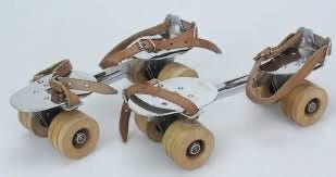Image d’une paire de patin à roulette en fer avec des lanières en cuire pour pouvoir les attacher par dessus des chaussures 