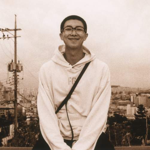 Namjoon on Instagram - sepia toned portrait with the city behind him. 