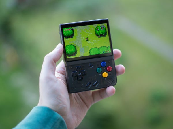 Photo of a Miyoo Mini Plus emulator handheld showing Zelda The Minish Cap on it's screen