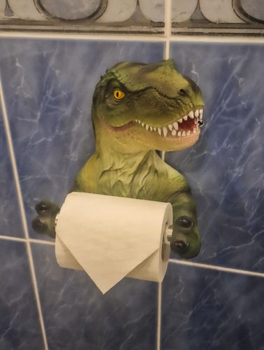 A toilet paper holder that looks like a T-Rex