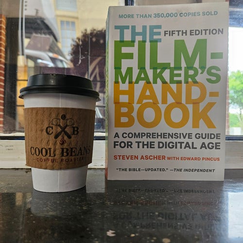 A cup of coffee and a copy of the filmmakers handbook. 