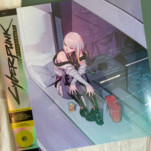 Image of an illustrated cyberpunk edgerunners vinyl album cover featuring an anime-style female character sitting on a bench with a futuristic city background, reflecting a cyberpunk aesthetic.