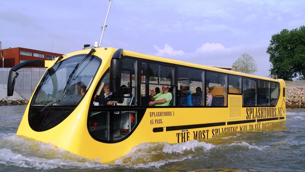 An amphibian vehicle which looks like a regular yellow passenger bus, swimming through water.