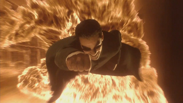 Neo flying faster than a raging explosion behind him.