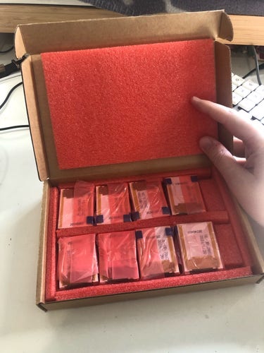 a small box containing displays. there are 8 baggies containing 4 displays each, and they’re neatly packed into two rows with padding foam around each baggie