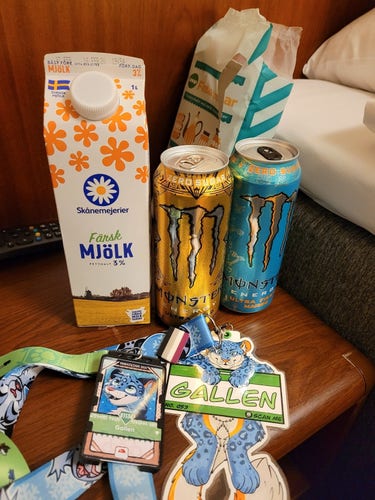 two cans of monster, a carton of milk and my con badges