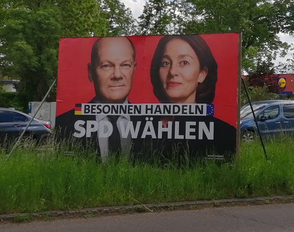 Ein großes Straßenplakat der SPD

Roter Hintergrund, zwei Köpfe, links Scholz, rechts eine Frau.

Darüber die Schrift

"Besonnen Handeln - SPD Wählen" 