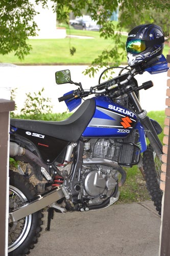 2002 Dr650 SE. Blue. Road and lawn in the background.
