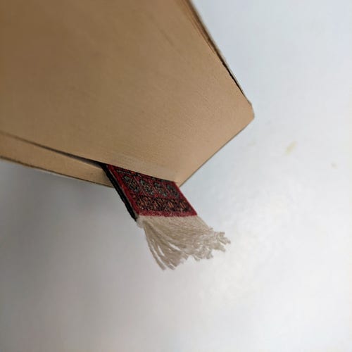 Close up of the top corner of a novel with a bookmark placed most of the way toward the end of the book