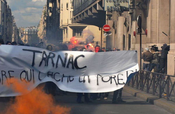 Activists march with a banner reading "Tarnac."
