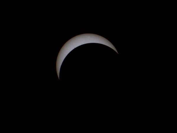 About three quarters of the way to totality. The Sun now takes on a perfect crescent shape. The edge of the Moon encroaches on the smaller sunspot cluster in the upper left portion of the Sun's disk.