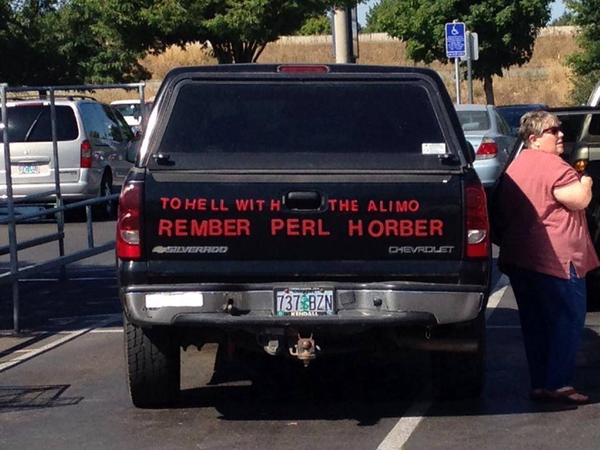 A black pickup truck with a canopy. A rather large woman stands to the right of it.

The back of the pickup truck has large red letter stickers spelling out the sentence, "To hell with the Alimo (sic), rember (sic) Perl (sic) Horber (sic)."