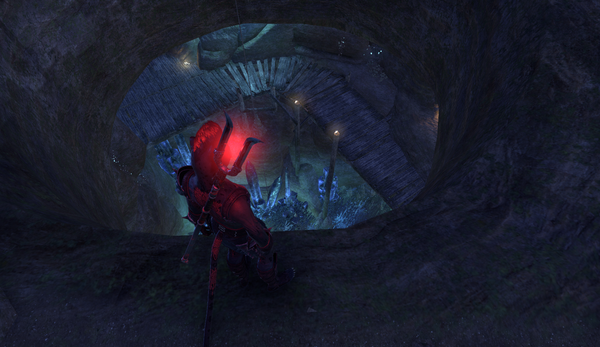My khajiit toon, with his luridly red-glowing staff slung on his back, stands at the brink of a large dark hole in the ground, looking down into the shadow depths where can be seen some rickety-looking wooden catwalks edging a pool of faintly glowing liquid of unknown content and depth.