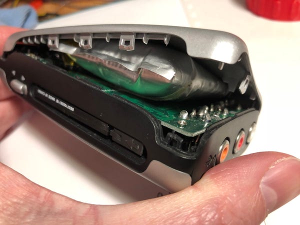 Side view of an M-Audio MicroTrack recorder where the case has been forced apart by a swelling/bulging and failing internal battery in a silvery plastic "pillow".