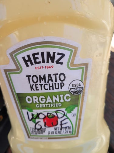Hein Tomato Ketchup bottle full of yellow substance, with "wood glue" written on label.