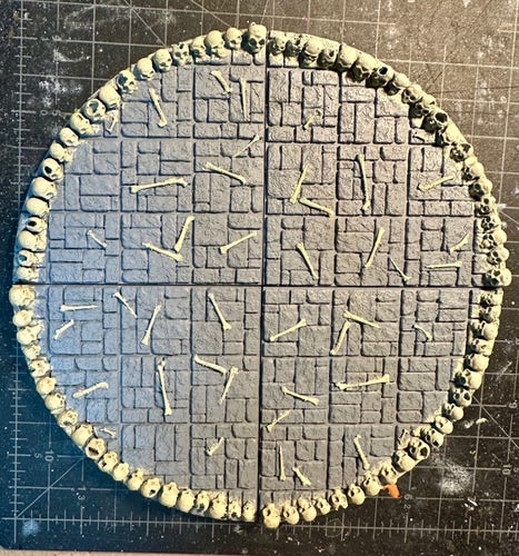 Four dungeon tiles for the Tower of Terror. Each segment represents a quarter of a circle. The stone floor is littered with bones and ringed with skulls.
