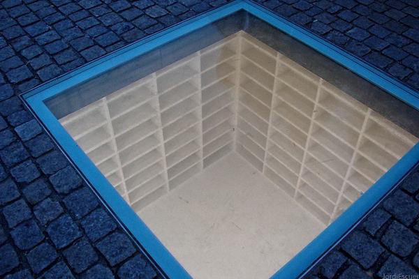 An white empty void in the street lined with empty white book shelves

Book Burning Memorial - Bebelplatz, Berlin - Germany