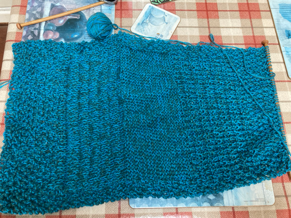 Half a hand knitted poncho in blue wool 