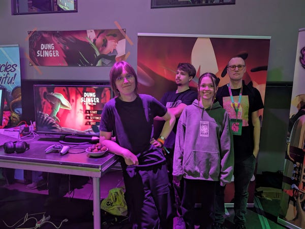 The team behind the game in front of their booth