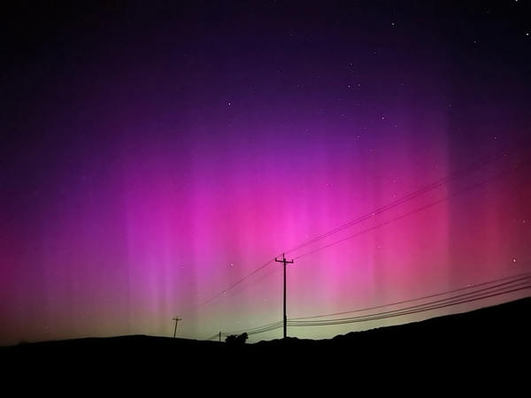 This image shows the aurora borealis — bright pink, purple, blue and red hues 