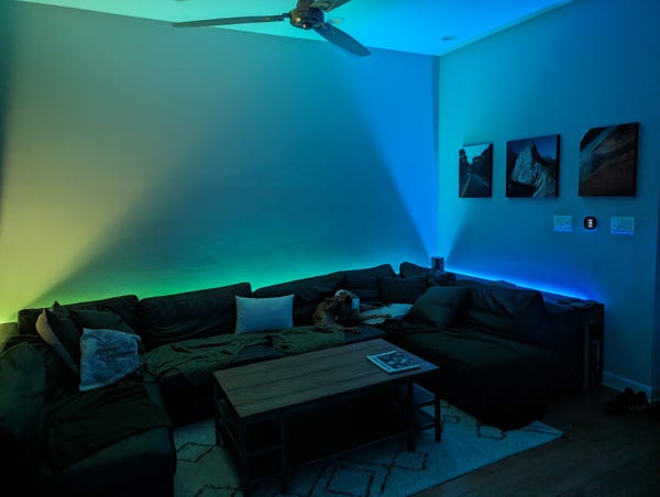 A couch lit in yellow to green to blue