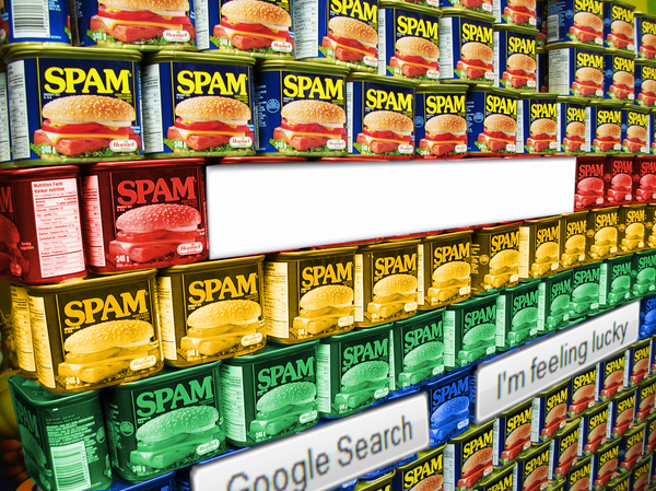 A wall of Spam cans stacked many layers high and deep. Superimposed over it are UI elements from the Google 1998 homepage: a search box, a 'Google Search' button, and an 'I'm feeling lucky' button. The middle four rows of Spam cans have been colorized to match the Google four-color logo tones.

Image:
freezelight (modified)
https://commons.wikimedia.org/wiki/File:Spam_wall_-_Flickr_-_freezelight.jpg

CC BY-SA 2.0
https://creativecommons.org/licenses/by-sa/2.0/deed.en