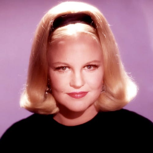 Peggy Lee - a soft-focus head-and-shoulders portrait of the singer - blonde hair with Alice band and black top. She looks piercingly at the camera with a half-smile.