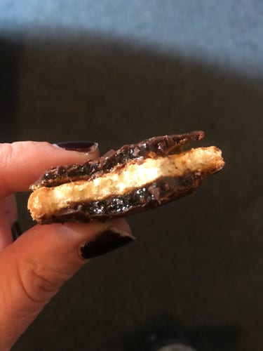 Image of a half-eaten JaffaCake to which a genius has affixed the top (chocolate and orange section) of a different Jaffa Cake. So there’s a layer of cake in the middle, sandwiched on top and bottom with orange/chocolate layers