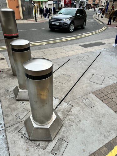 Two thick metal bollards, with tracks on the ground showing that they can be moved in a straight line