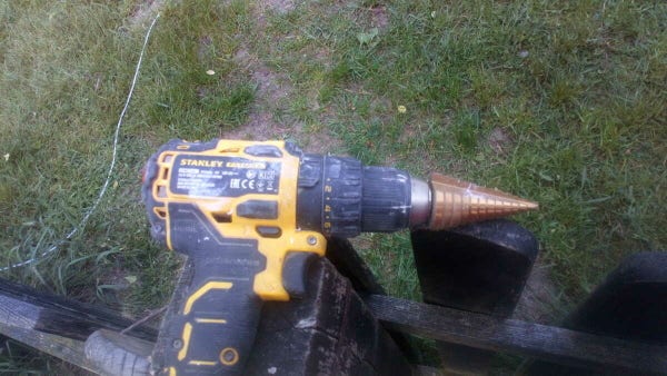 An electric drill with an attachment to make holes in plastic.