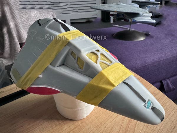 Delta Flyer model with 2 strips of yellow masking tape holding the cockpit in place while the glue sets