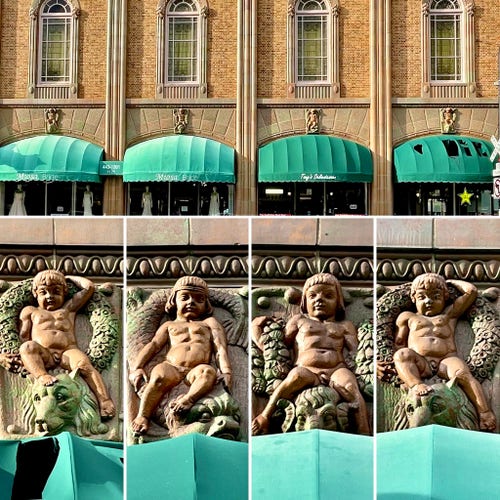 Exterior of an orange brick building with statues of some strangely muscular babies along the facade
