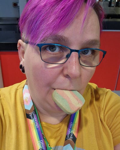 Me, eating a trans flag cookie,  at the FCC meeting