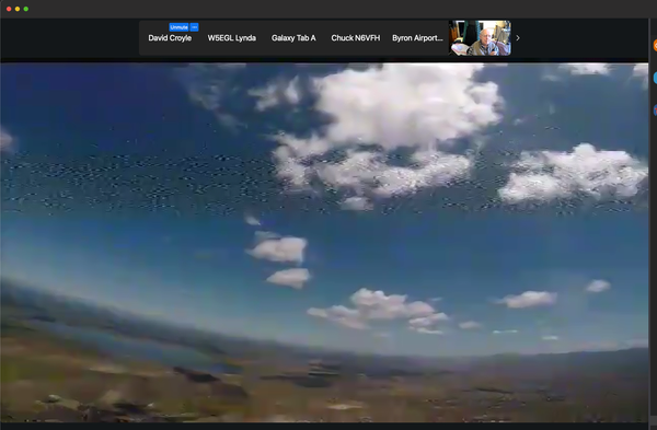 Screen capture of live parachute mobile video feed above Byron, CA today. Mostly clear skies with a few clouds, and the land below are the skydiver's view.