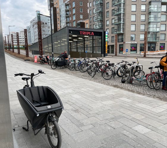 Bike Parking in front of Tripla mall in Helsinki. One urban arrow cargo bike in the foreground did not fit in the frame locking stands