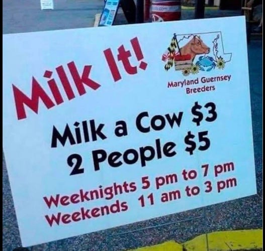 A large sign reads:
Milk It! 
Maryland Guernsey Breeders 

Milk a Cow $3 
2 People $5 

Weeknights 5 pm to 7 pm 
Weekends 11 am to 3 pm